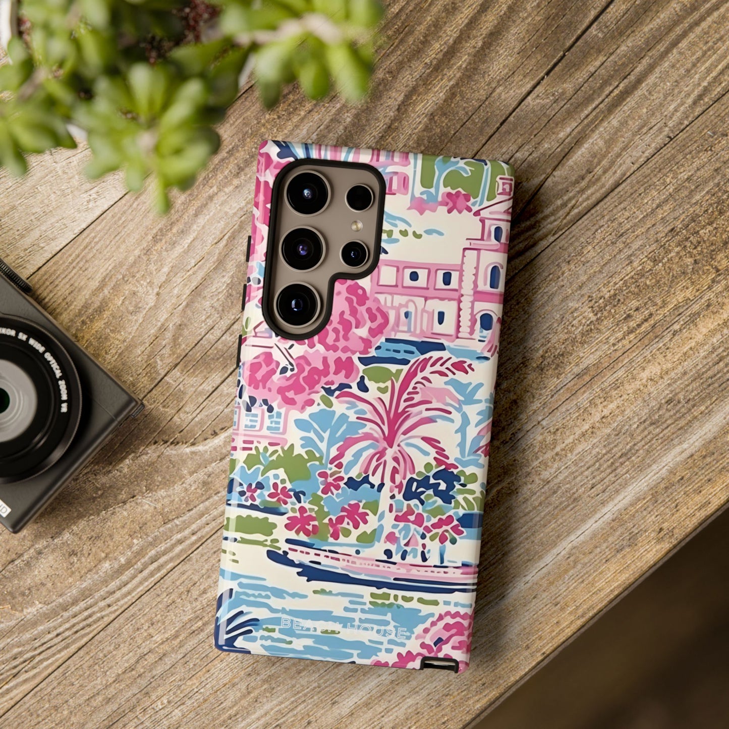 Colorful floral Amelia Tough Case for Galaxy on a wooden surface with a camera and plant in the background