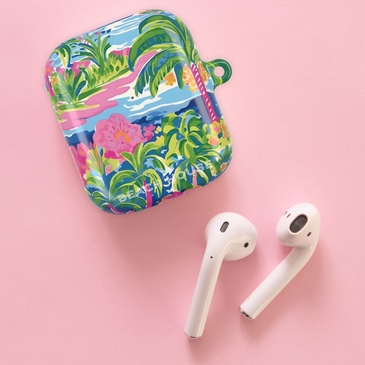 Kiawah Hard Case for Airpods next to earbuds on a pink background