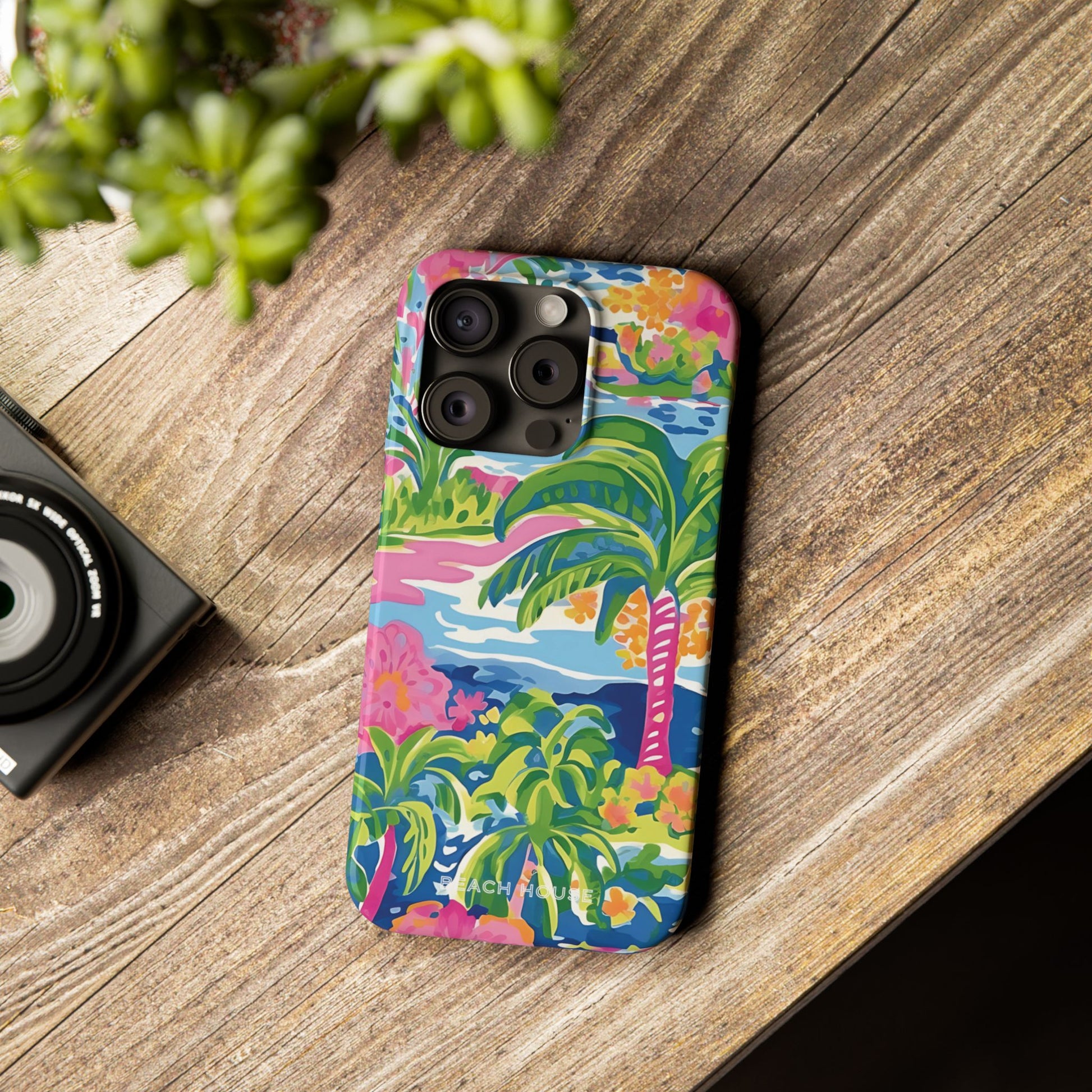 Colorful Kiawah Slim Case for iPhone with palm tree design on a wooden surface