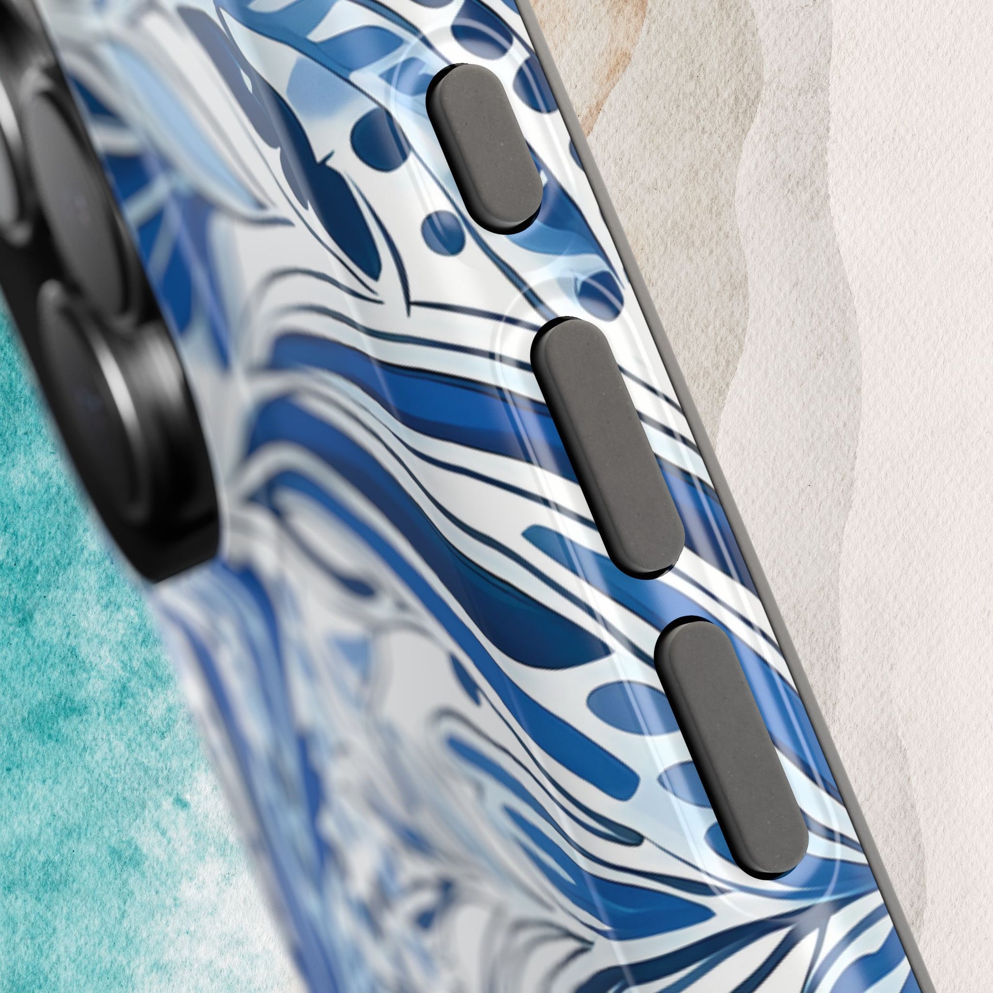 Close up view of the Nags Head MagSafe Tough Case for iPhone with blue and white abstract design on a beach background