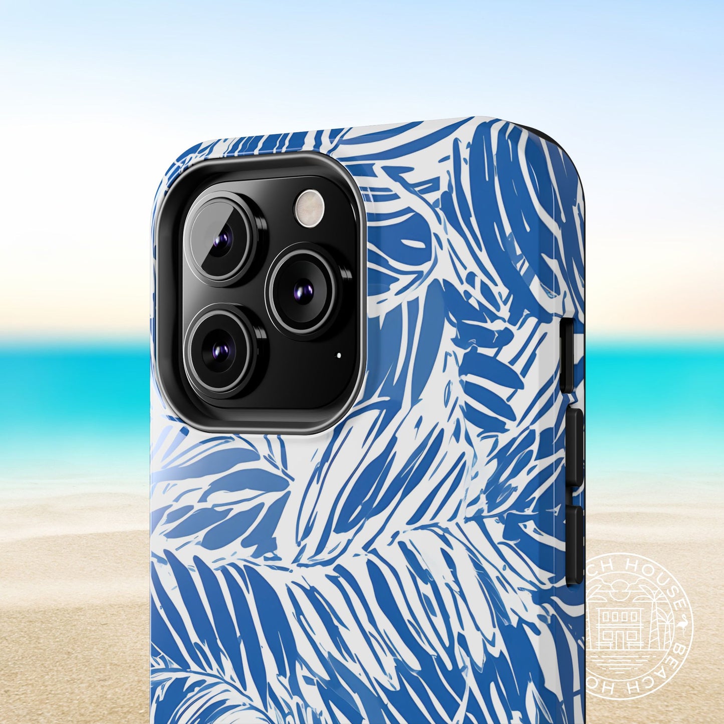 Hampton Tough Case for iPhone with blue and white palm leaf pattern on a beach background
