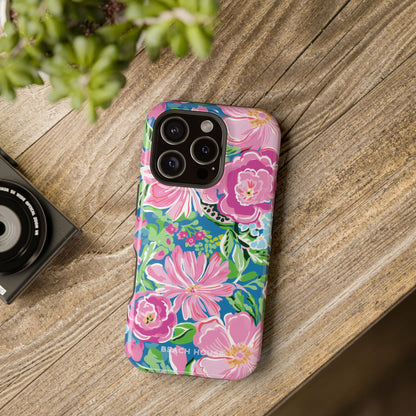 Floral Madeira MagSafe Tough Case for iPhone on a wooden surface with a camera and plant in the background