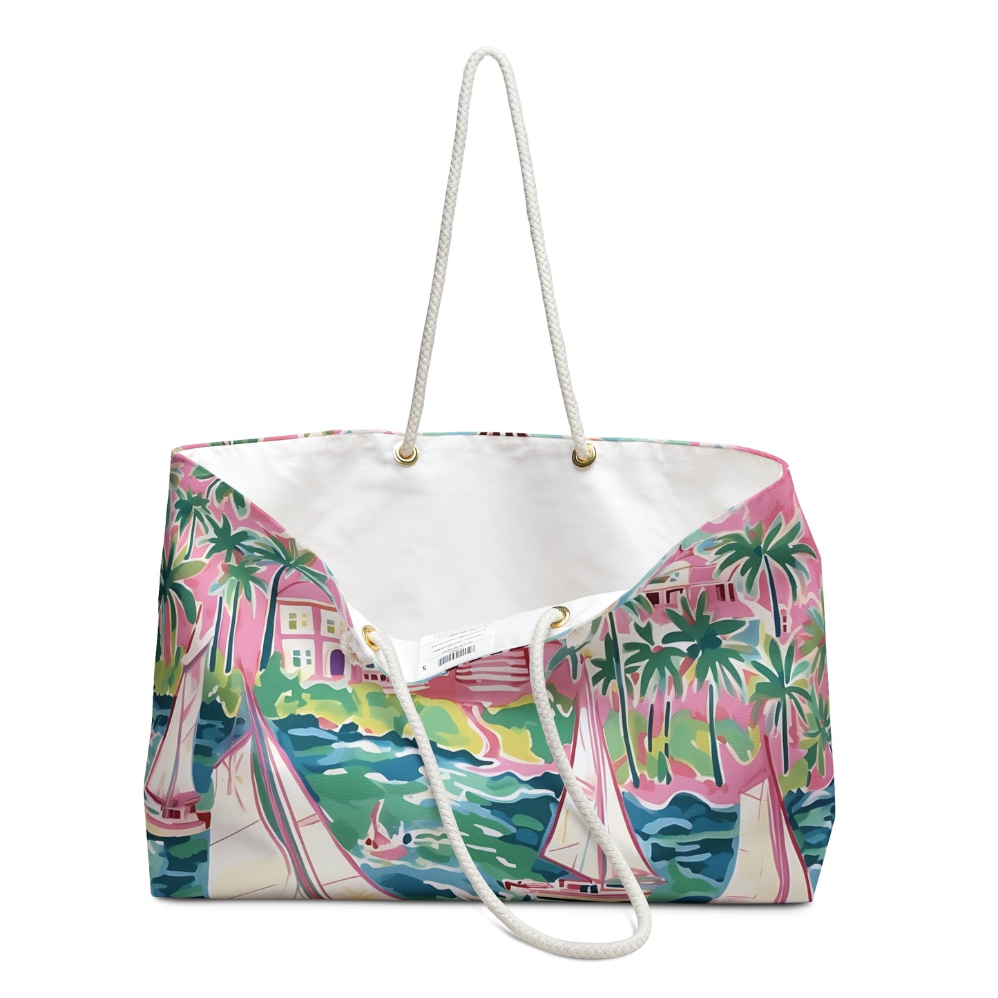 St. Simon Weekender tote bag opened to show cream lined interior and a tropical design featuring palm trees and boats on a white background.