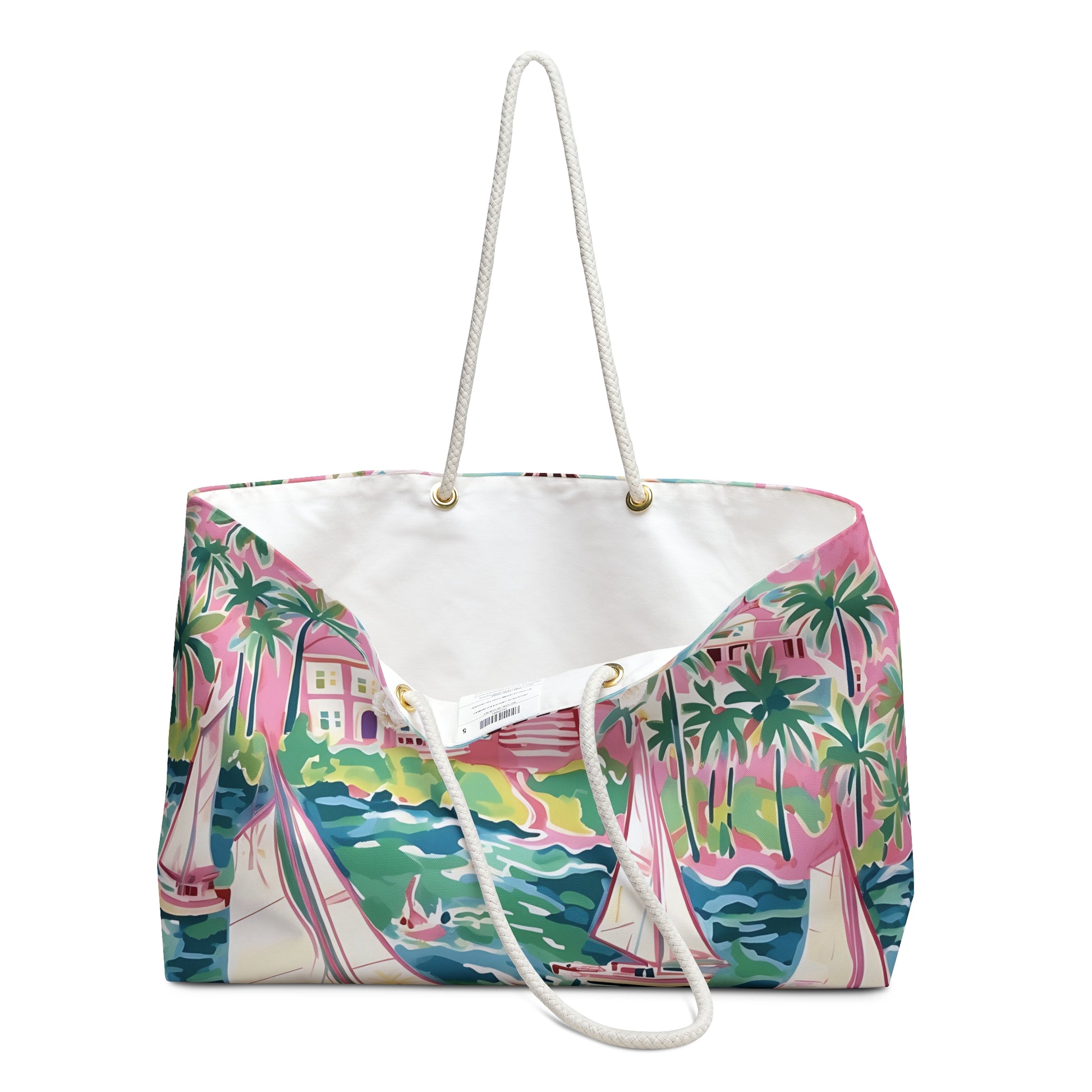 St. Simon Weekender tote bag opened to show cream lined interior and a tropical design featuring palm trees and boats on a white background.