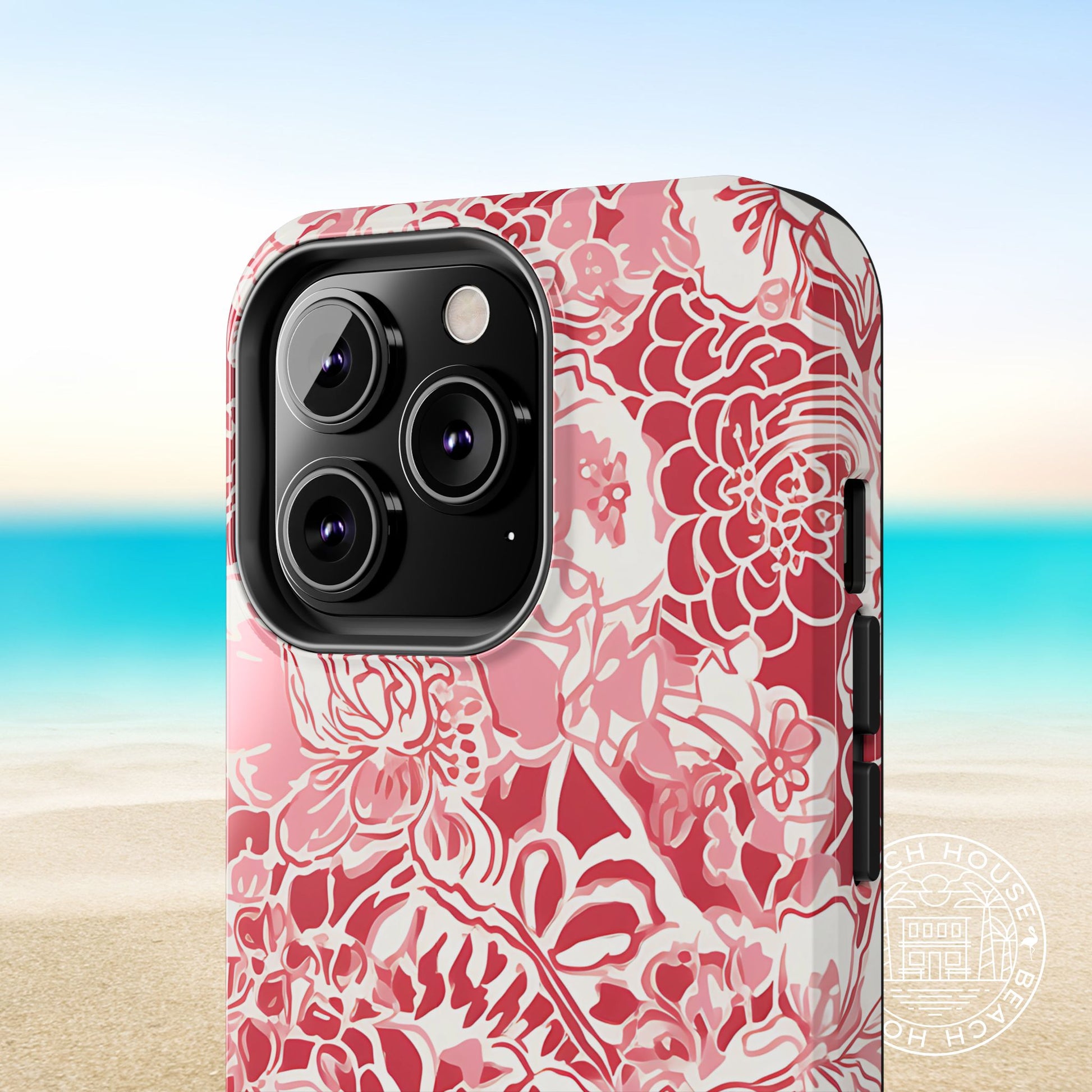 Norman Tough Case for iPhone with red floral pattern on a blurred beach background