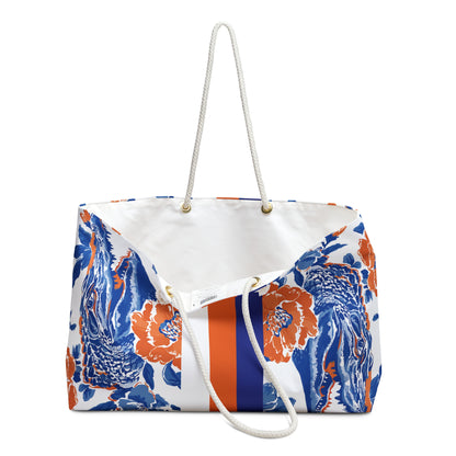 Slightly opened view of Gainesville Weekender Tote Bag with blue and orange floral pattern with a cream interior liner, on a white background