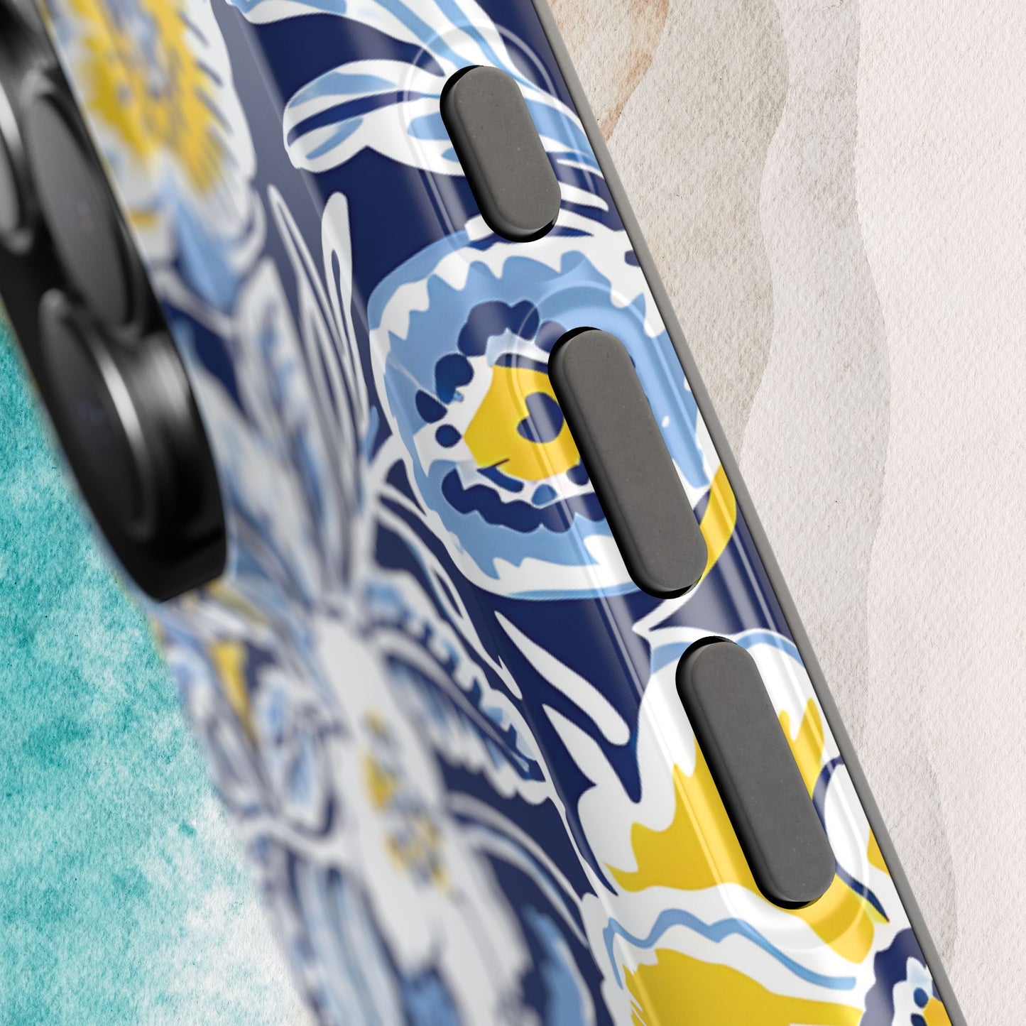 Close up view of buttons on the Ann Arbor MagSafe Tough Case for iPhone, on a textured surface