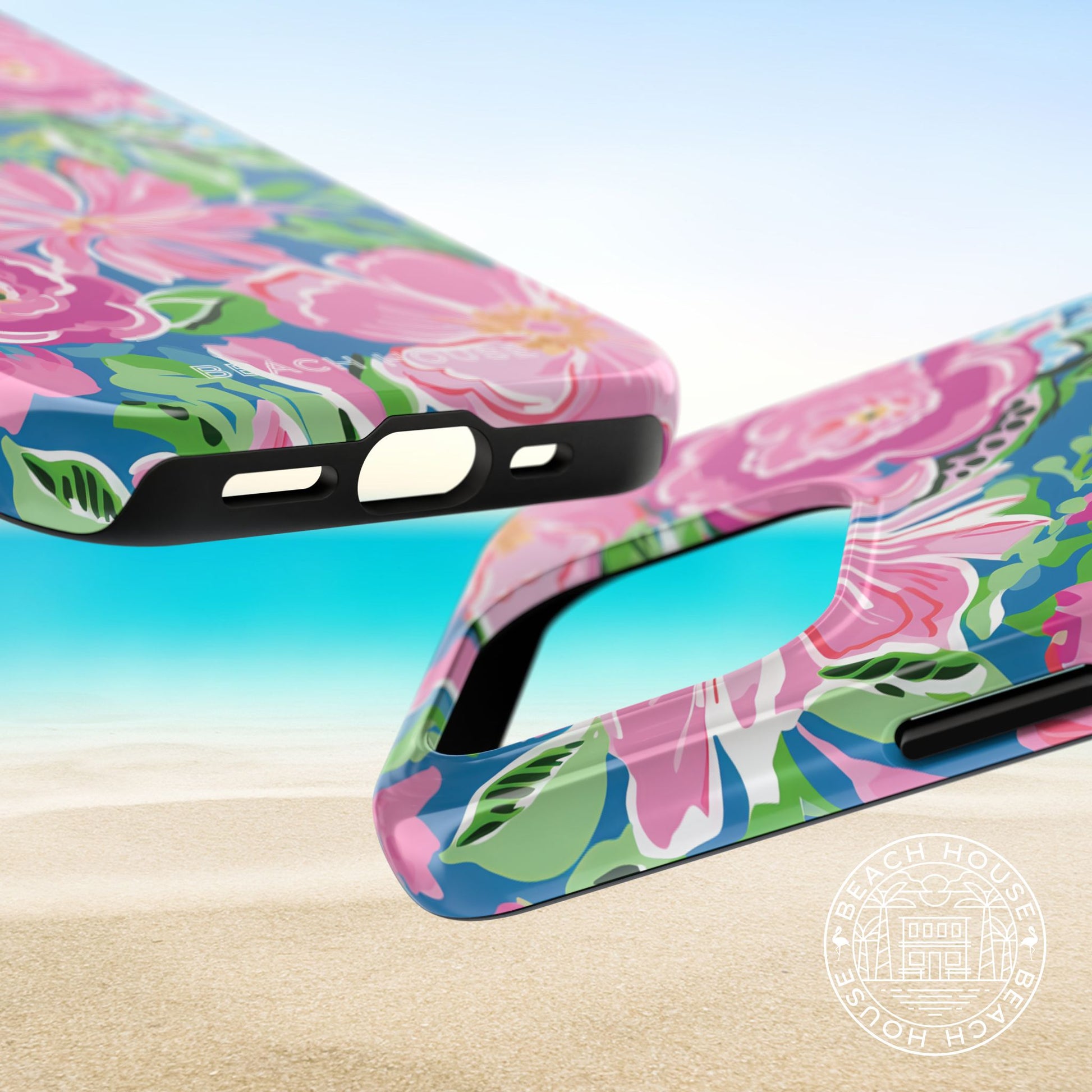 Top and bottom of the Madeira Tough Case for iPhone on a beach with a clear blue sky