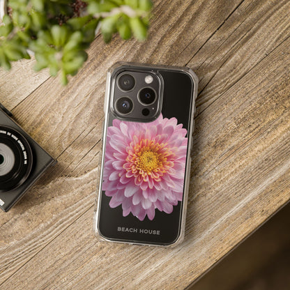 Phone case with a pink flower design on a wooden surface next to a camera