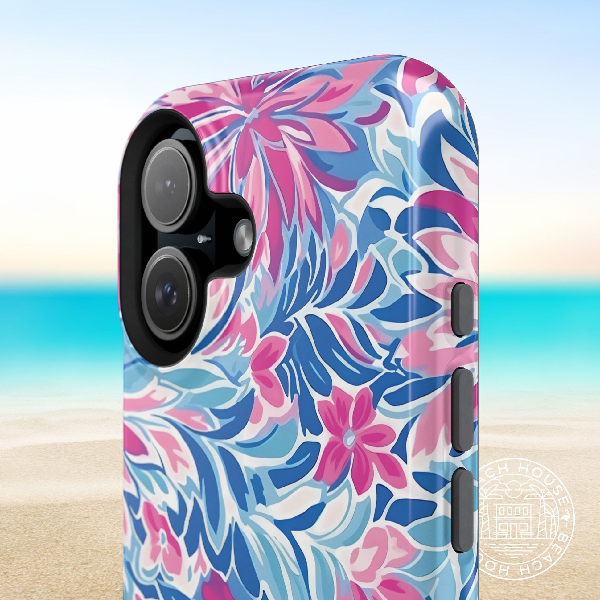Close up view of the Destin MagSafe Tough Case for iPhone with pink and blue vibrant pattern on a beach background