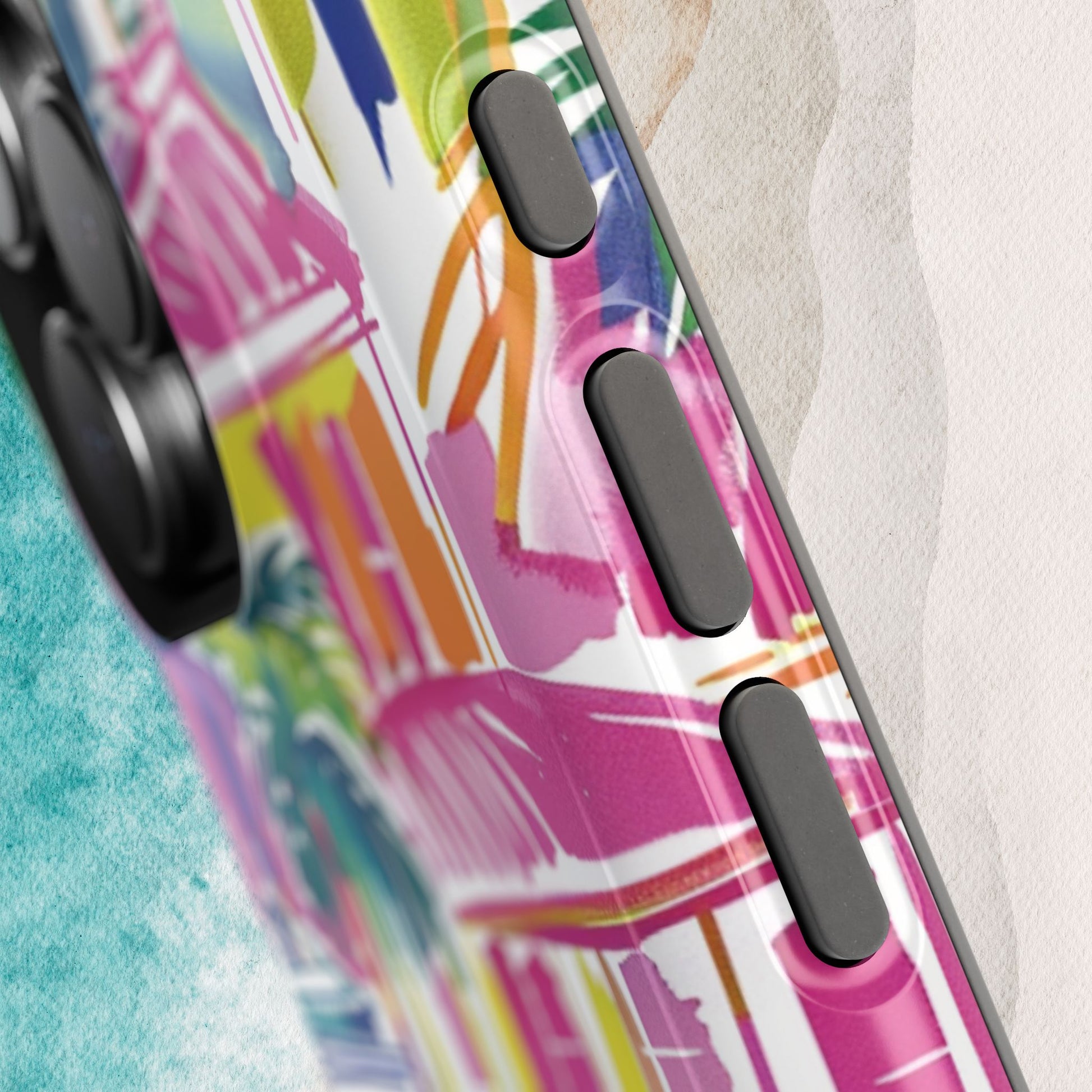 Close up view of buttons on the George Town MagSafe Tough Case for iPhone, on a textured surface