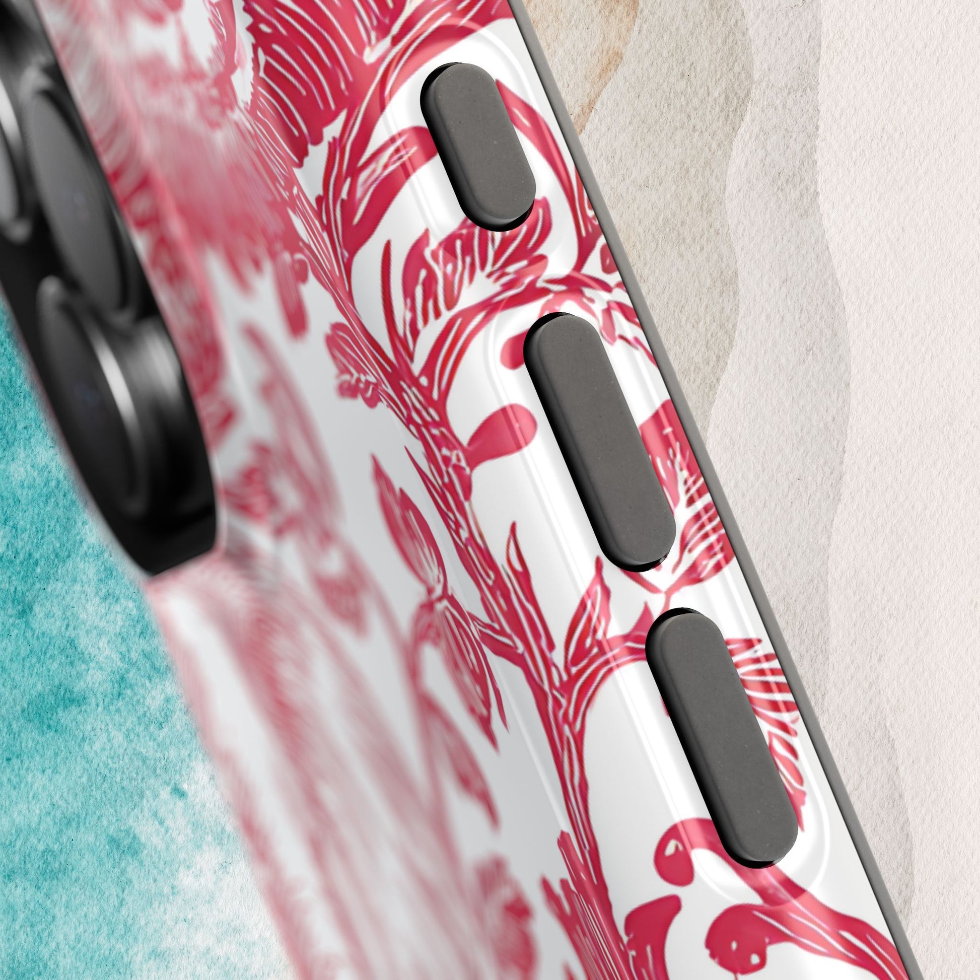 Detailed view of buttons on the Tuscaloosa MagSafe Tough Case for iPhone with red and white tropical design on a textured surface