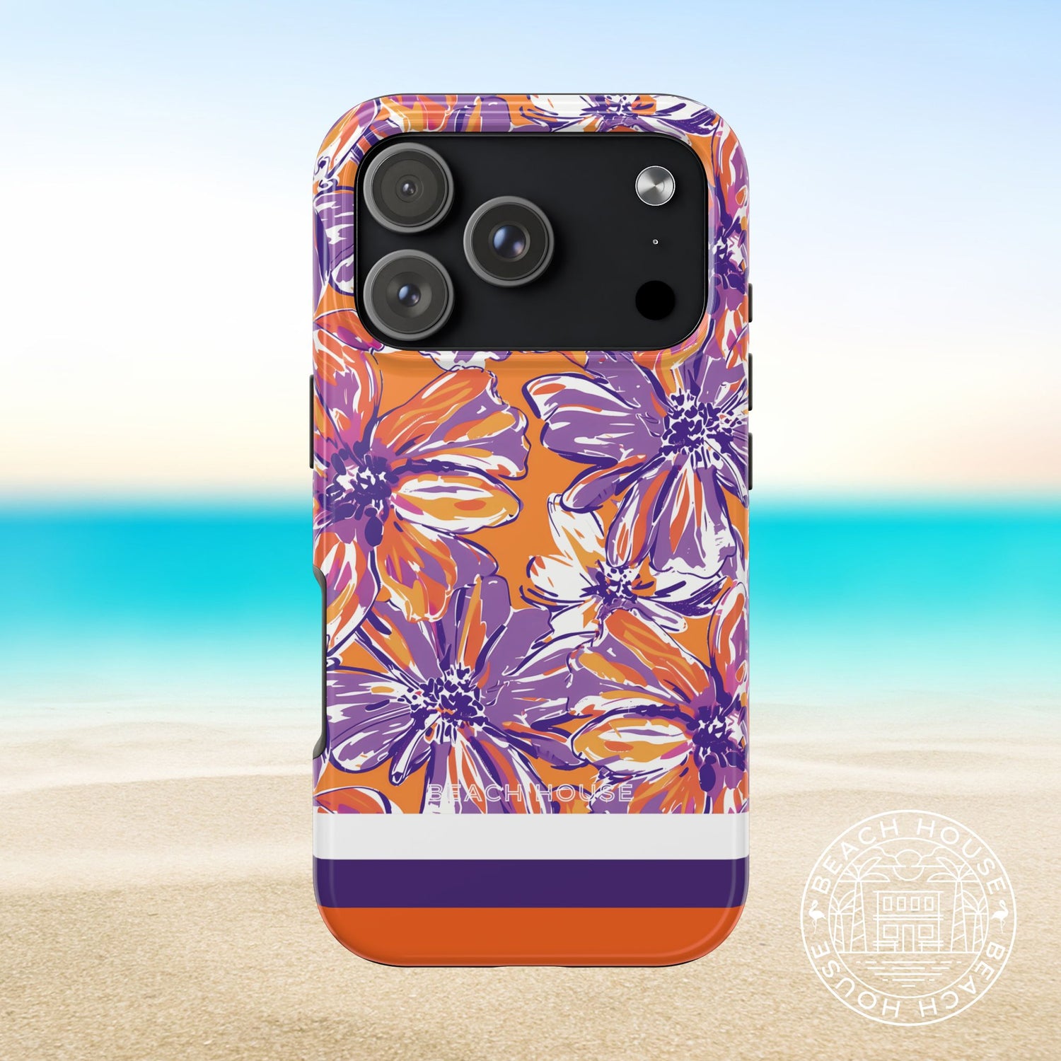 Clemson Tough Case for iPhone 17 pro with purple and orange floral design on a beach background
