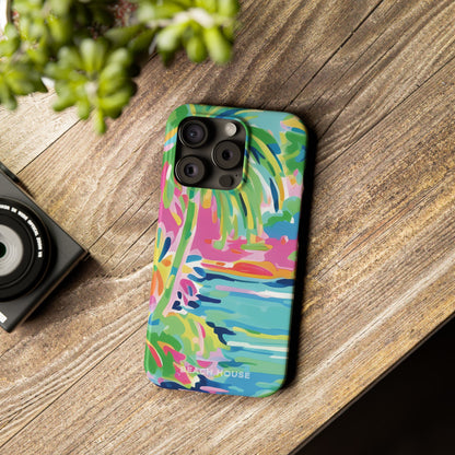 Colorful Delray Slim Case for iPhone with a dog design on a wooden surface next to a camera and plant.