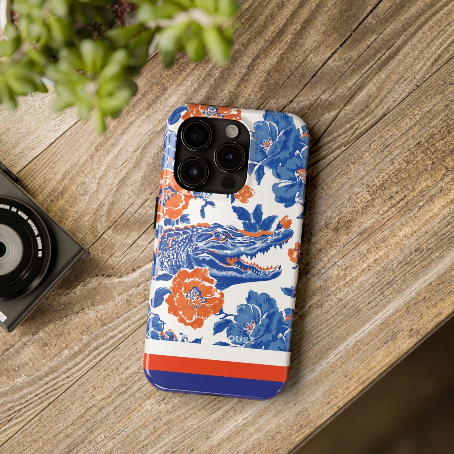 Gainesville Tough Case for iPhone with floral and gator design on a wooden surface