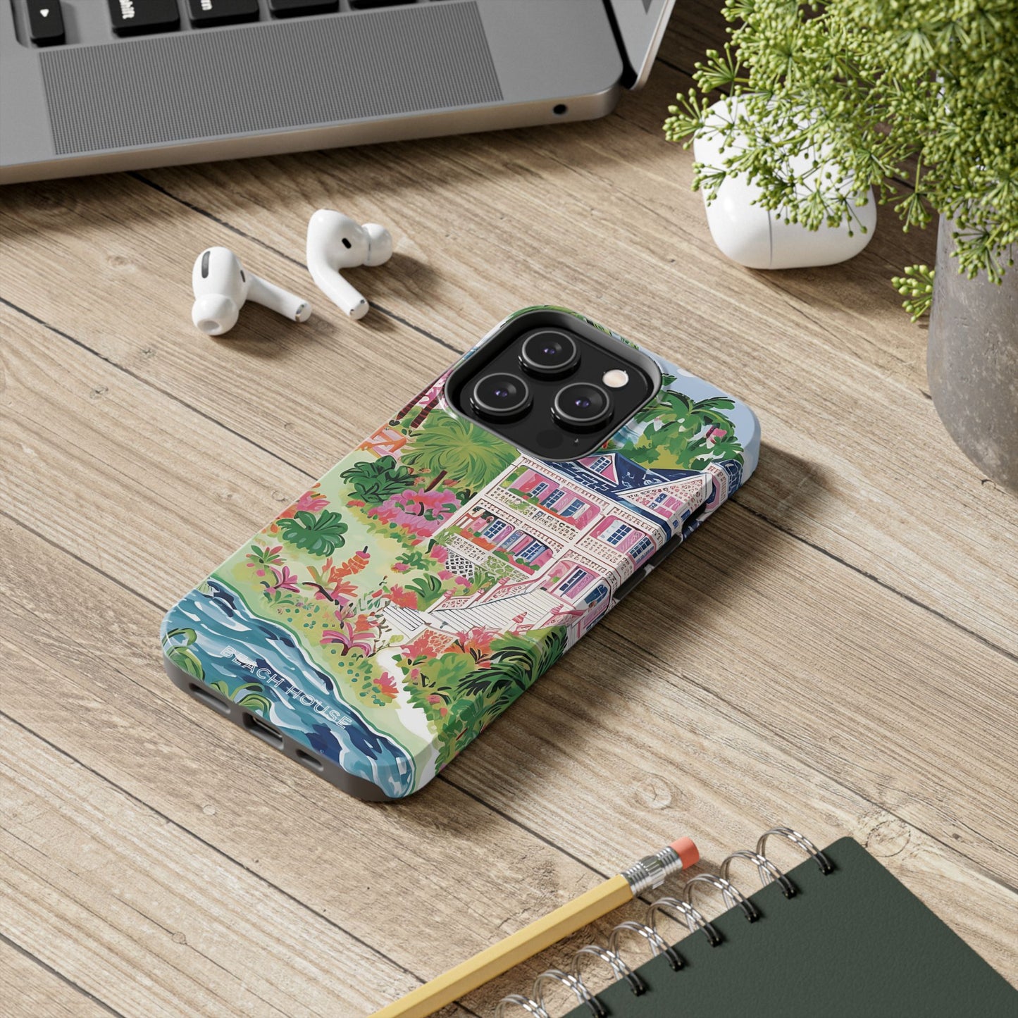 Charleston Tough Case for iPhone with colorful design on a wooden surface with laptop, earbuds, and notebook.