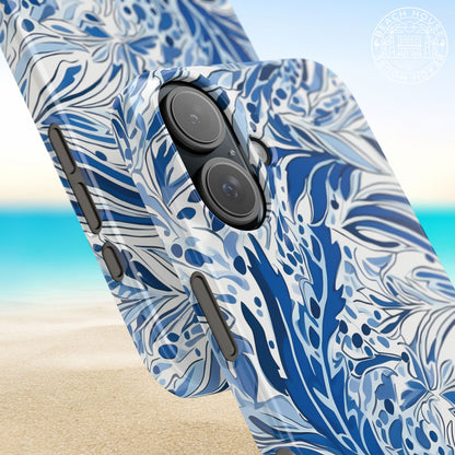 Close up view of a blue and white floralNags Head Slim Case for iPhone on a beach background