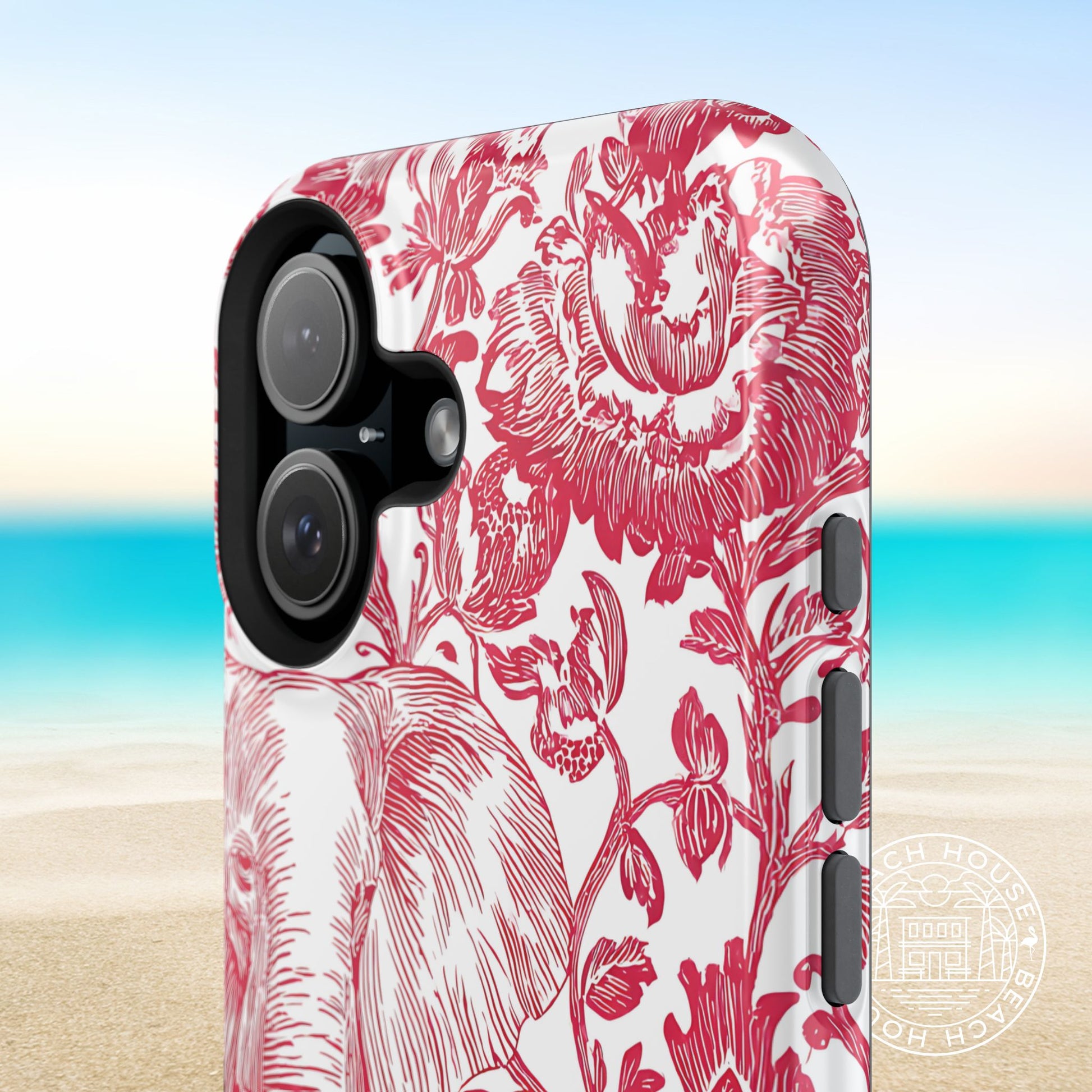 Close up view of the Tuscaloosa MagSafe Tough Case for iPhone with red floral pattern on a beach background