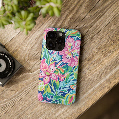 Colorful floral Fernandina Tough Case for iPhone case on a wooden surface with a camera and plant in the background