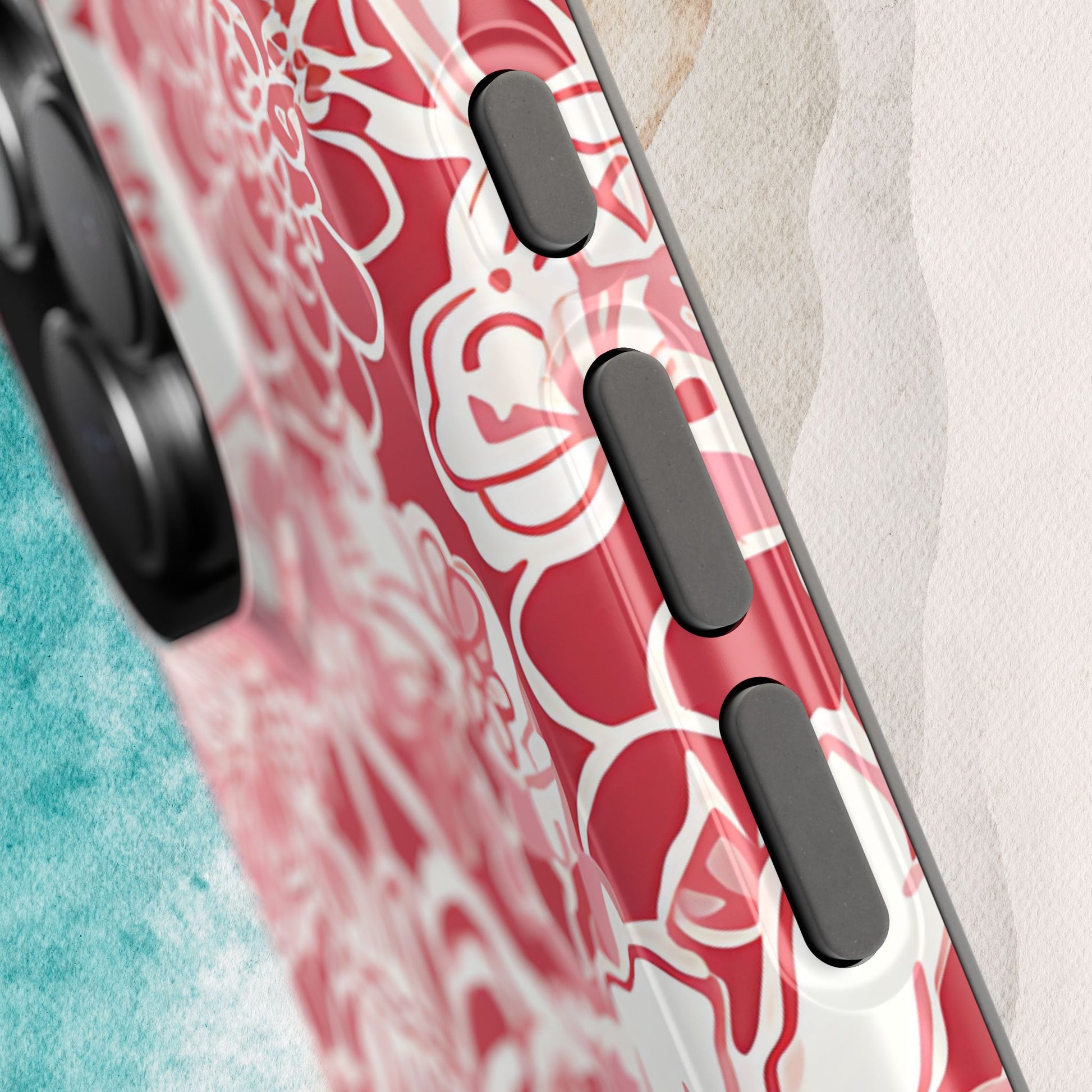 Side button detail on the Norman MagSafe Tough Case for iPhone on a textured surface