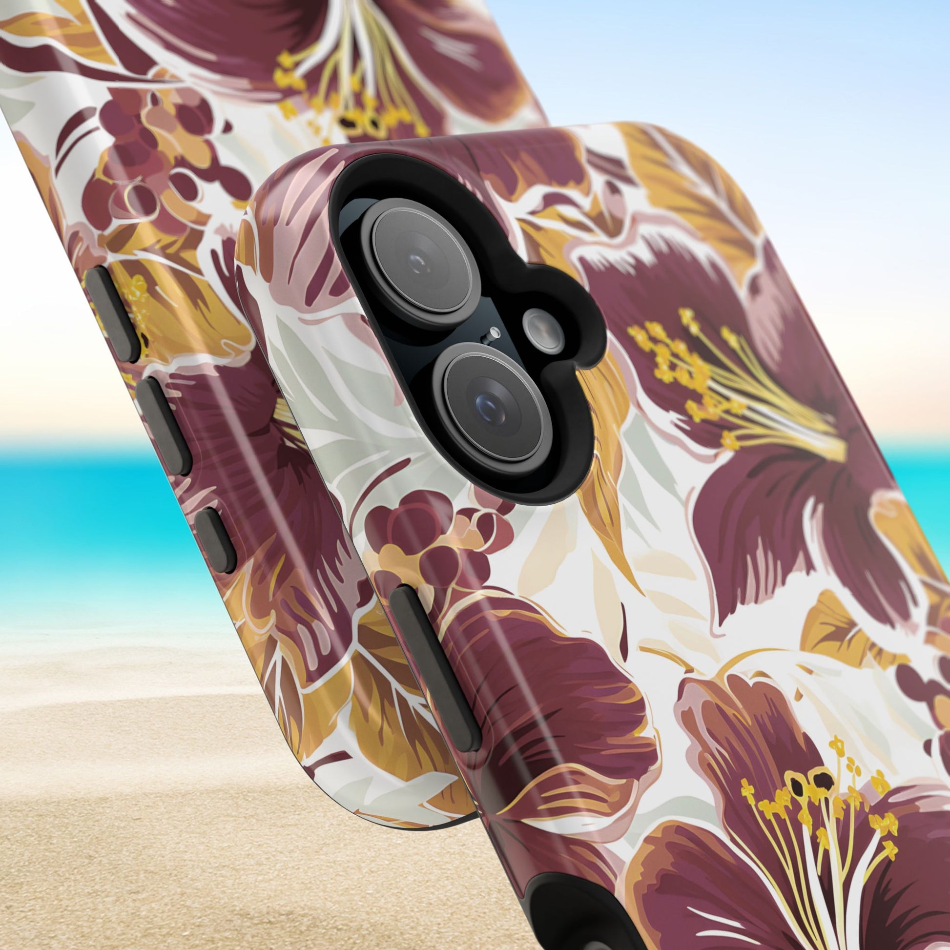 Close up views of the Tallahassee MagSafe Tough Case for iPhone with floral design on a beach background
