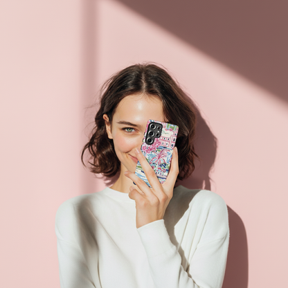 Woman holding a phone with a colorful Amelia Tough Galaxy Case against a pink background