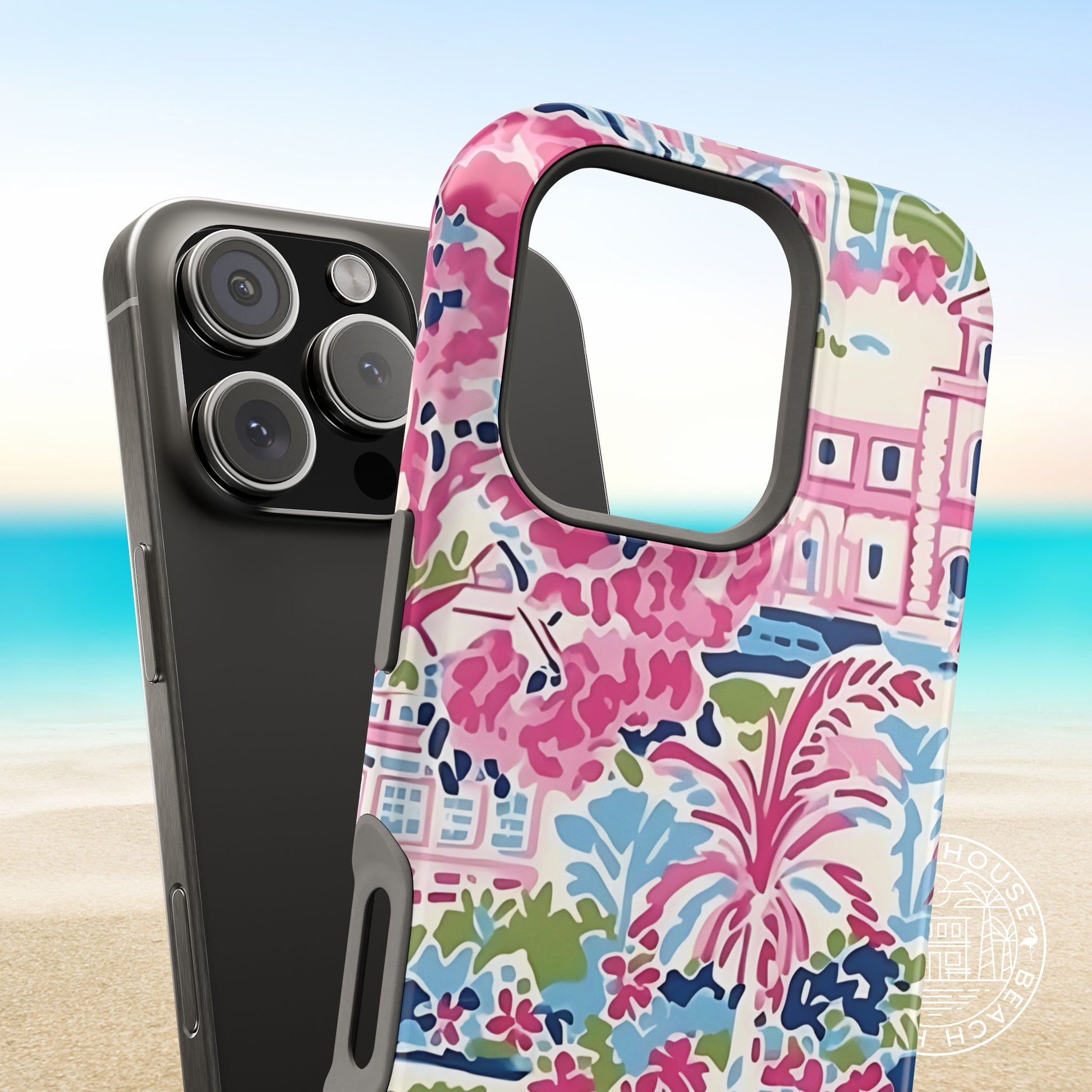 Colorful floral Amelia MagSafe Tough Case for iPhone, next to phone on a beach background