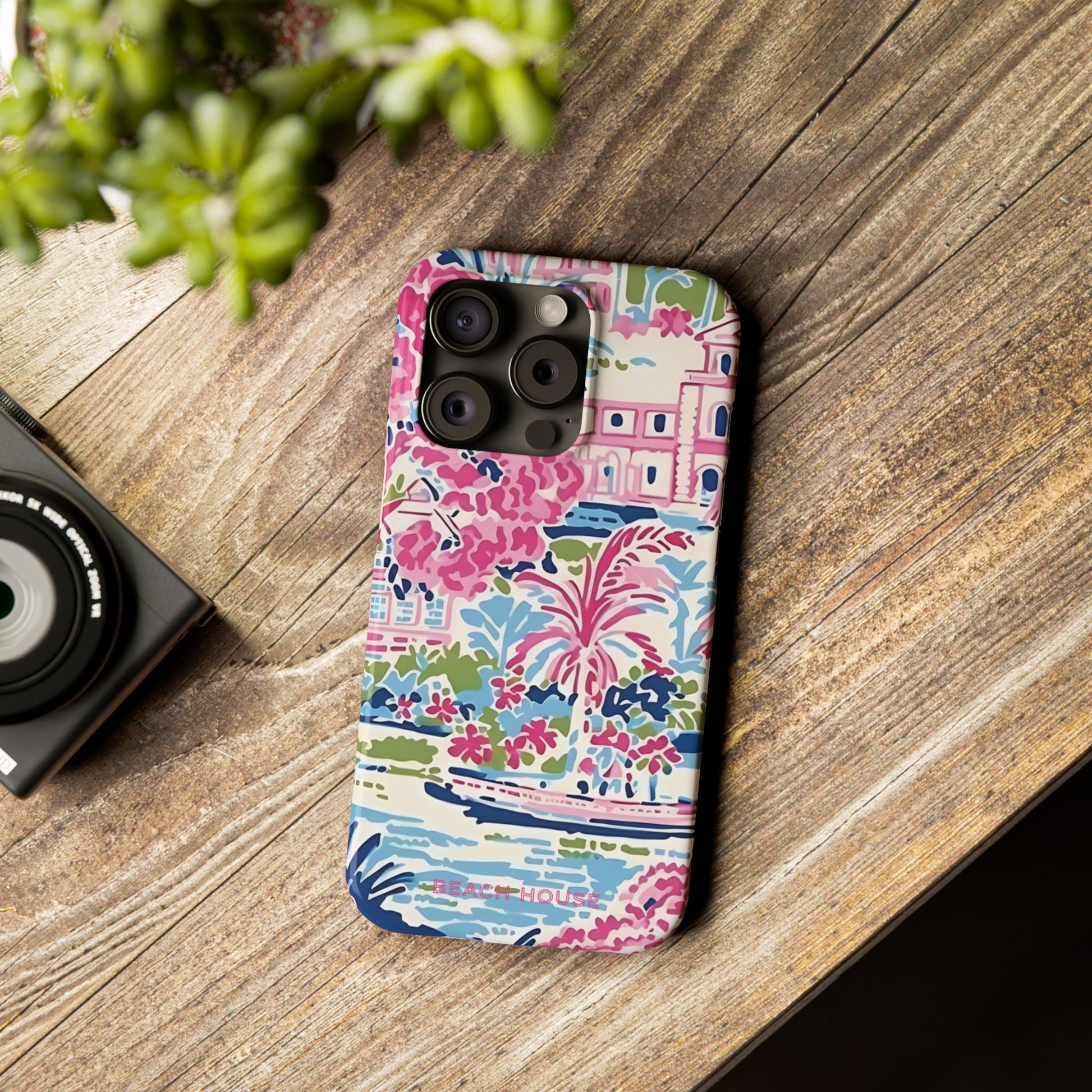 Amelia Slim Case for iPhone with colorful design on a wooden surface next to a camera