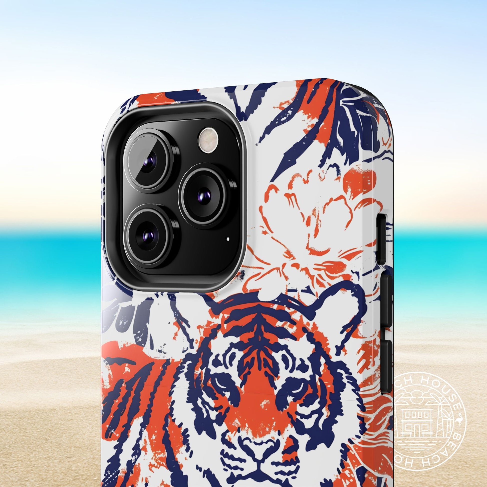 Close up view of Auburn Tough Case for iPhone with tiger design on a beach background
