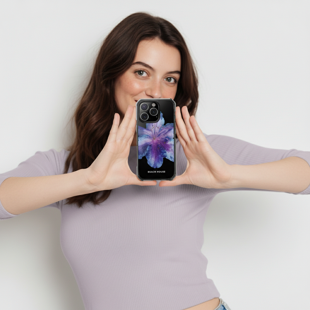 Woman holding a phone with a colorful case against a plain background