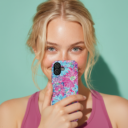 Woman holding a phone with a colorful floral case against a teal background