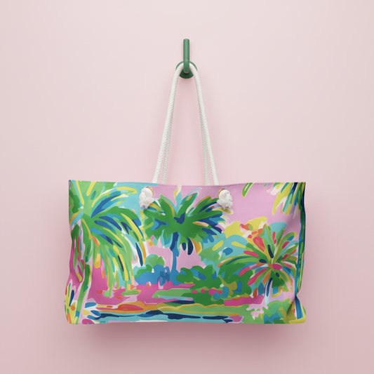 Delray Weekender vacation bag, rope handles hanging on a hook, on a pink background