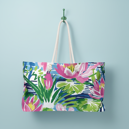 Lightweight Everglades weekender tote bag with tropical floral design, hanging on hook against a light blue wall