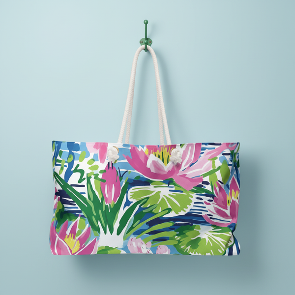 Lightweight Everglades weekender tote bag with tropical floral design, hanging on hook against a light blue wall