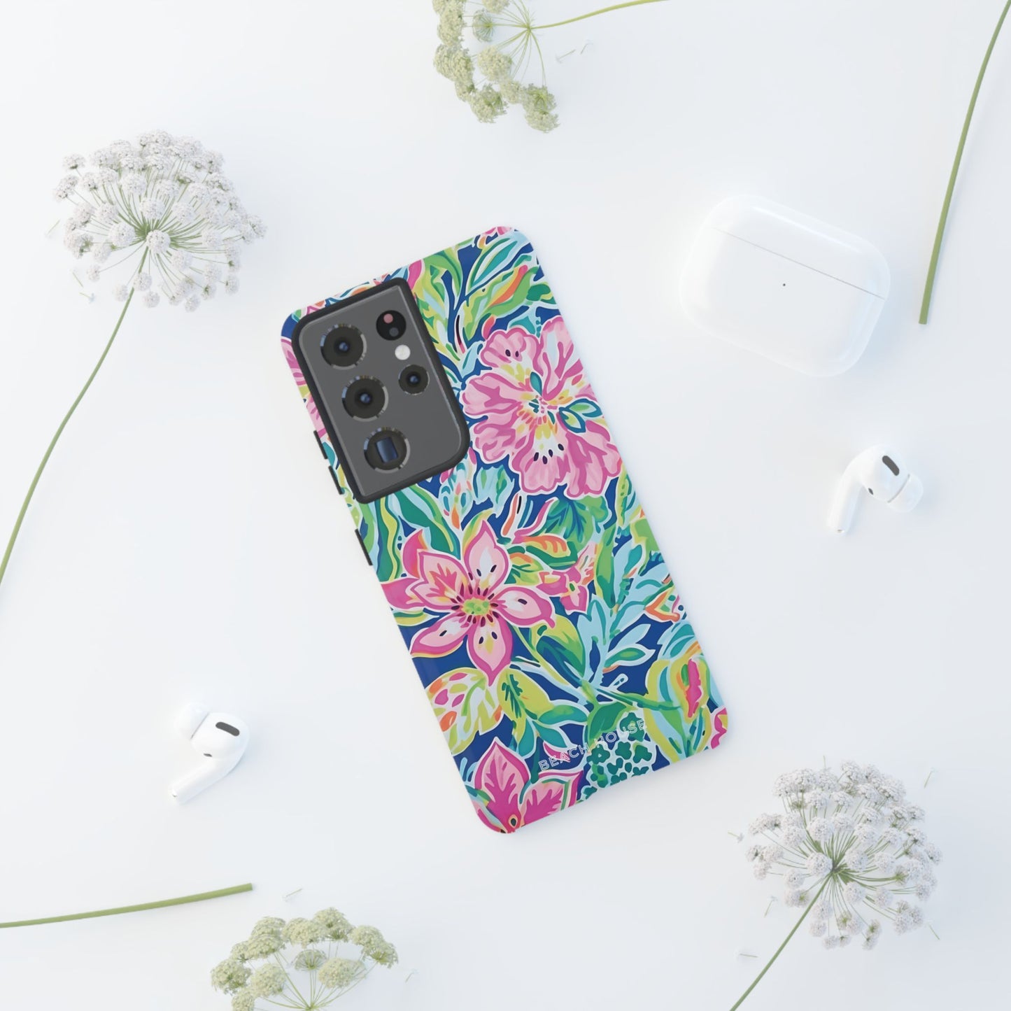 Fernandina Tough Case for Galaxy with colorful floral design on a white surface with earbuds and flowers nearby