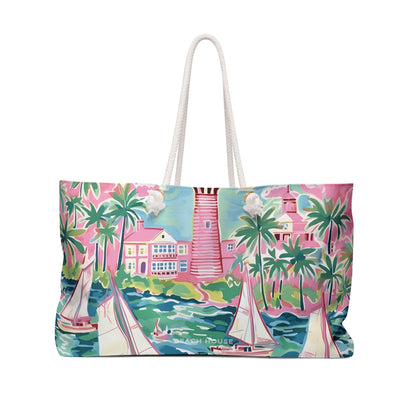 Front side of the St. Simon Weekender tote bag with a tropical scene featuring sail boats, palm trees and a lighthouse.