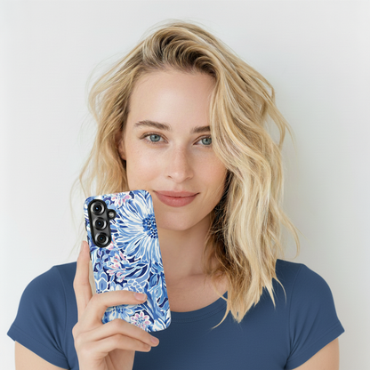 Woman holding a phone with a blue floral case against a white background