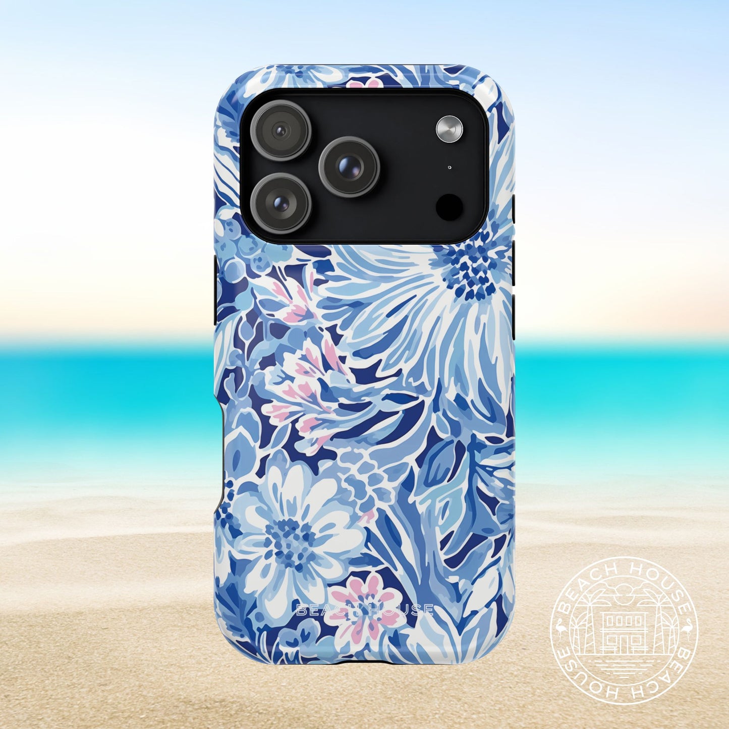 Blue floral Huntington MagSafe Tough phone case for iPhone 17 Pro on a beach background