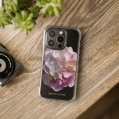 Phone case with floral design on a wooden surface next to a camera