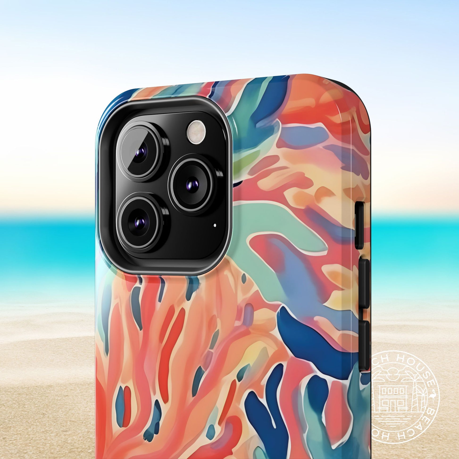 Close up view of the Key Biscayne Tough Case for iPhone with a coral design, with a beach background