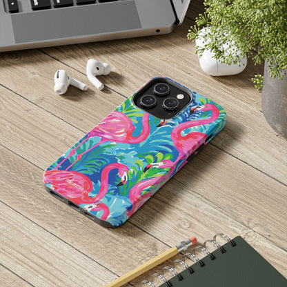 Phone case with flamingo design on a wooden surface with laptop, earbuds, and notebook.