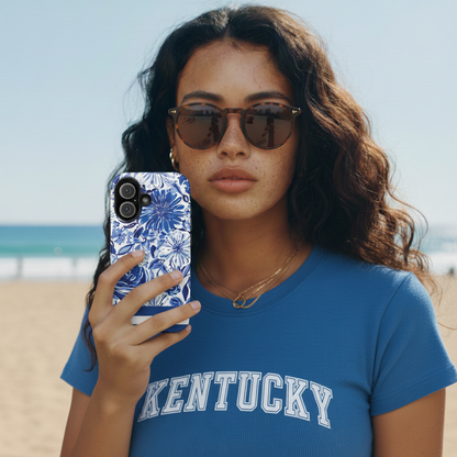 Woman holding a phone with a floral Lexington MagSafe Tough Case for iPhone on a beach
