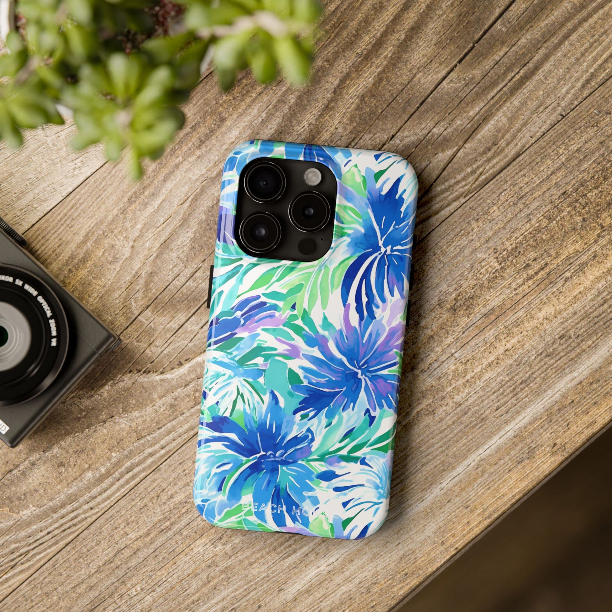 Longboat Tough Case for iPhone with blue and green floral pattern on a wooden surface