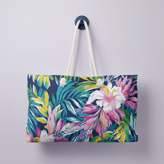 Playa Hermosa Weekender Tote Bag with tropical floral pattern hanging on a hook against a light purple background