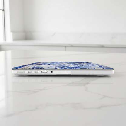 Laptop with a blue and white Santorini MacBook Case on a white marble surface