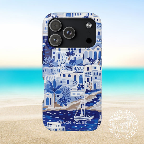 Santorini Tough Case for iPhone 17 Pro with beach house design on a blurred beach background