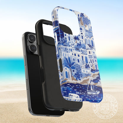 Protective Shell and shock absorbent liner layers of the Santorini Tough Case for iPhone next to a phone on a beach background