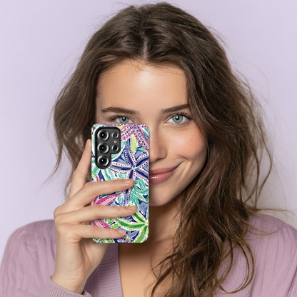 Woman holding a phone with a colorful case against a light purple background