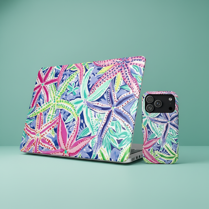 A laptop and iphone with tropical, starfish themed Siesta Key cases designed by Beach House, on a aqua colored surface