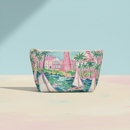 Cosmetic bag with tropical design featuring a lighthouse, palm trees, and sailboat on a pastel background.